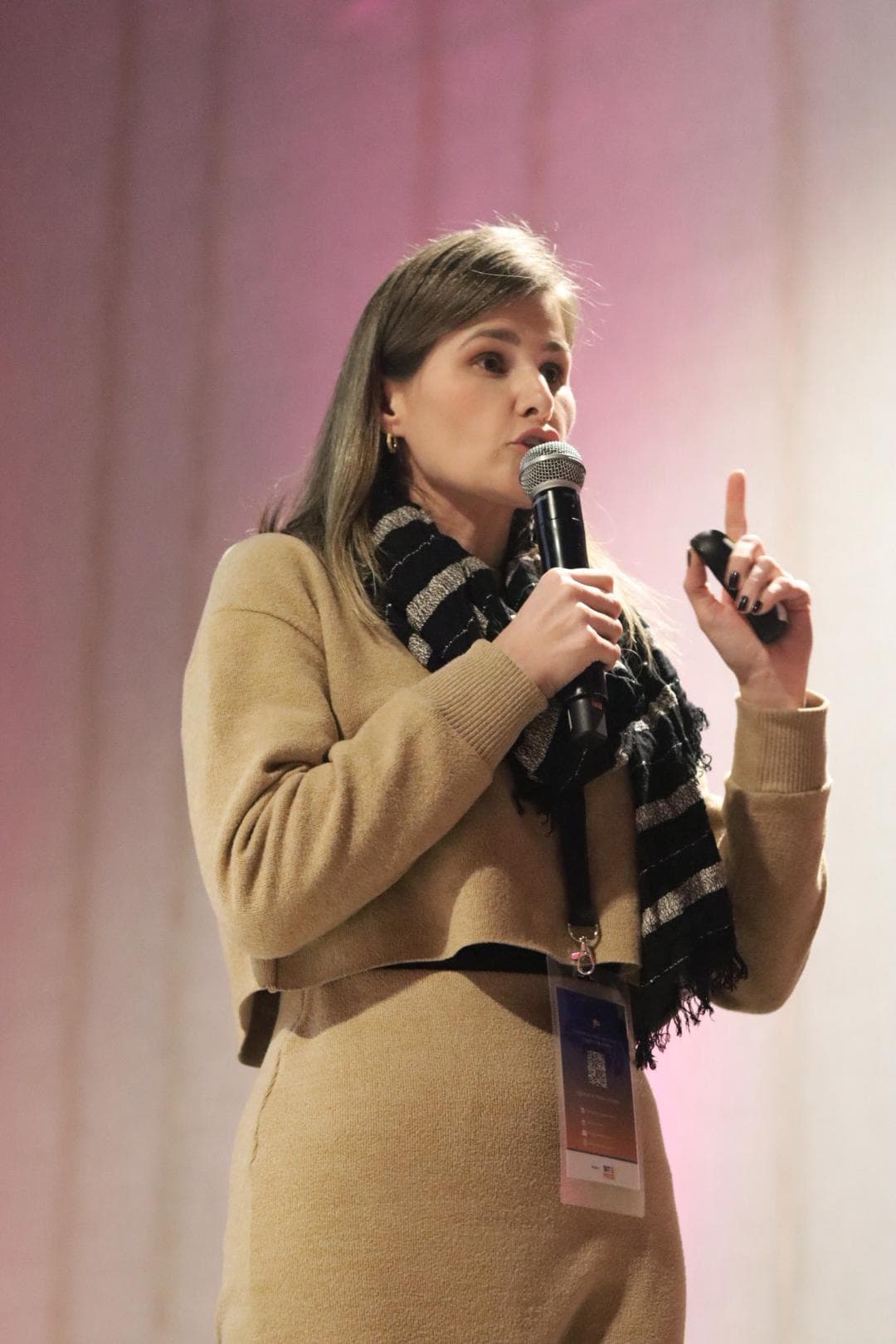 Jaqueline Baiocchi falando ao microfone durante uma palestra